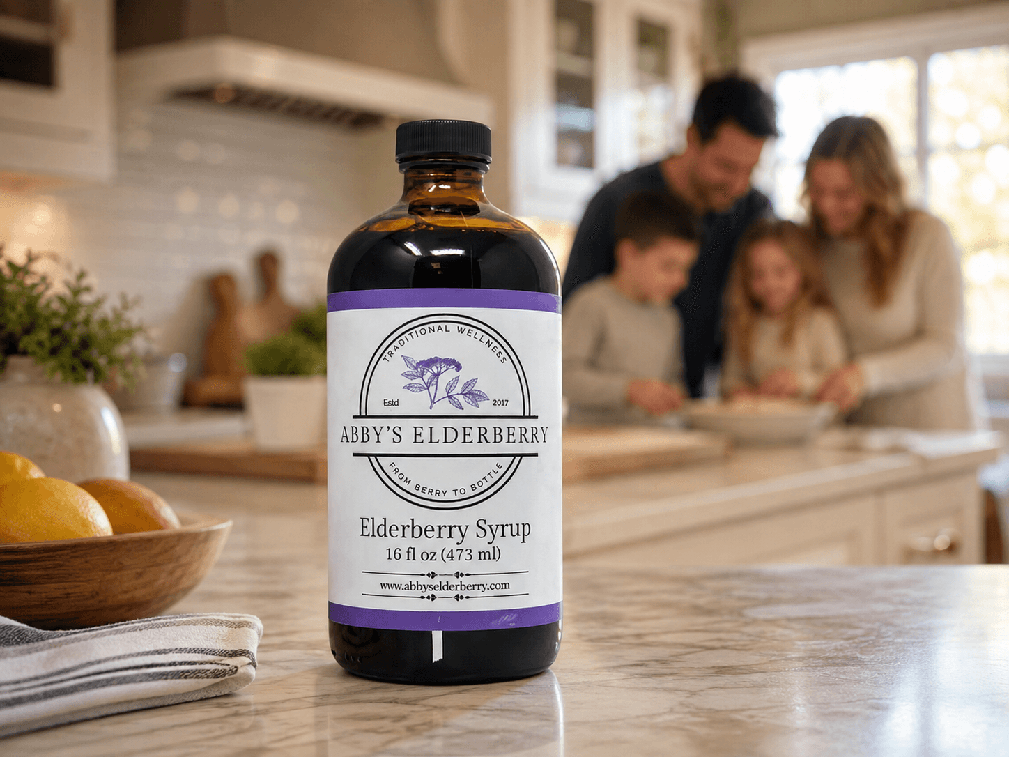 Abby's Elderberry small-batch elderberry syrup on a family kitchen counter, with parents and kids cooking behind it