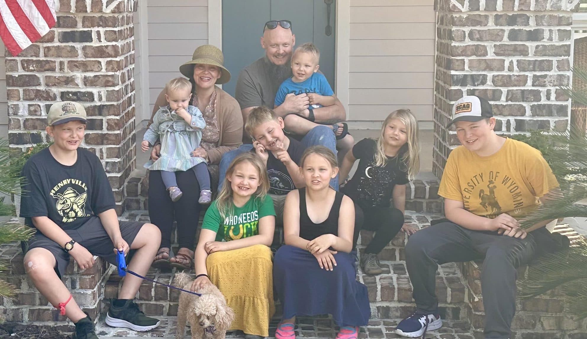 The Walker family and their children gathered on the front porch with the family dog