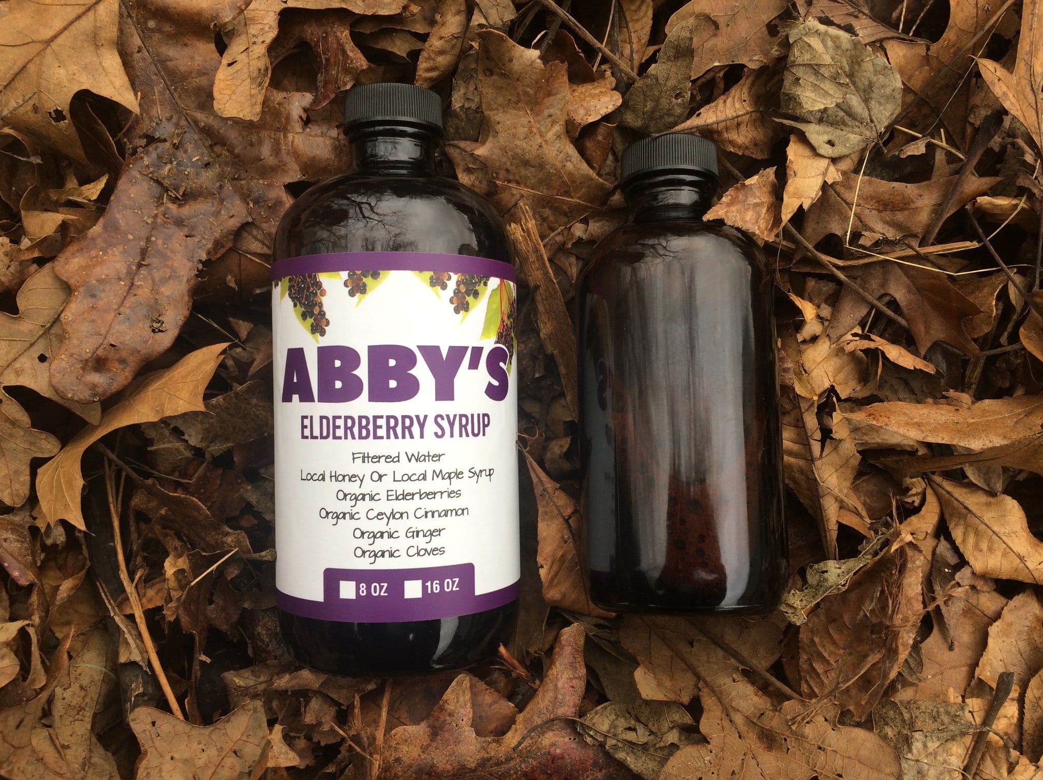 Abby's Elderberry 16 ounce and 8 ounce small-batch elderberry syrup bottles side by side